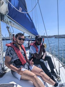 Two service users smiling at the camera while sailing